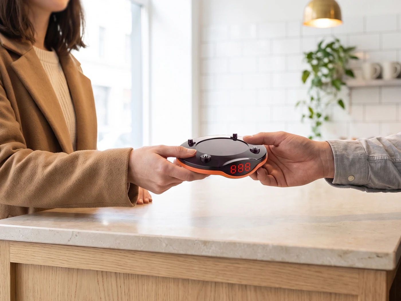 Staff member handing a vibrating Vycall pager to a customer at a food court counter