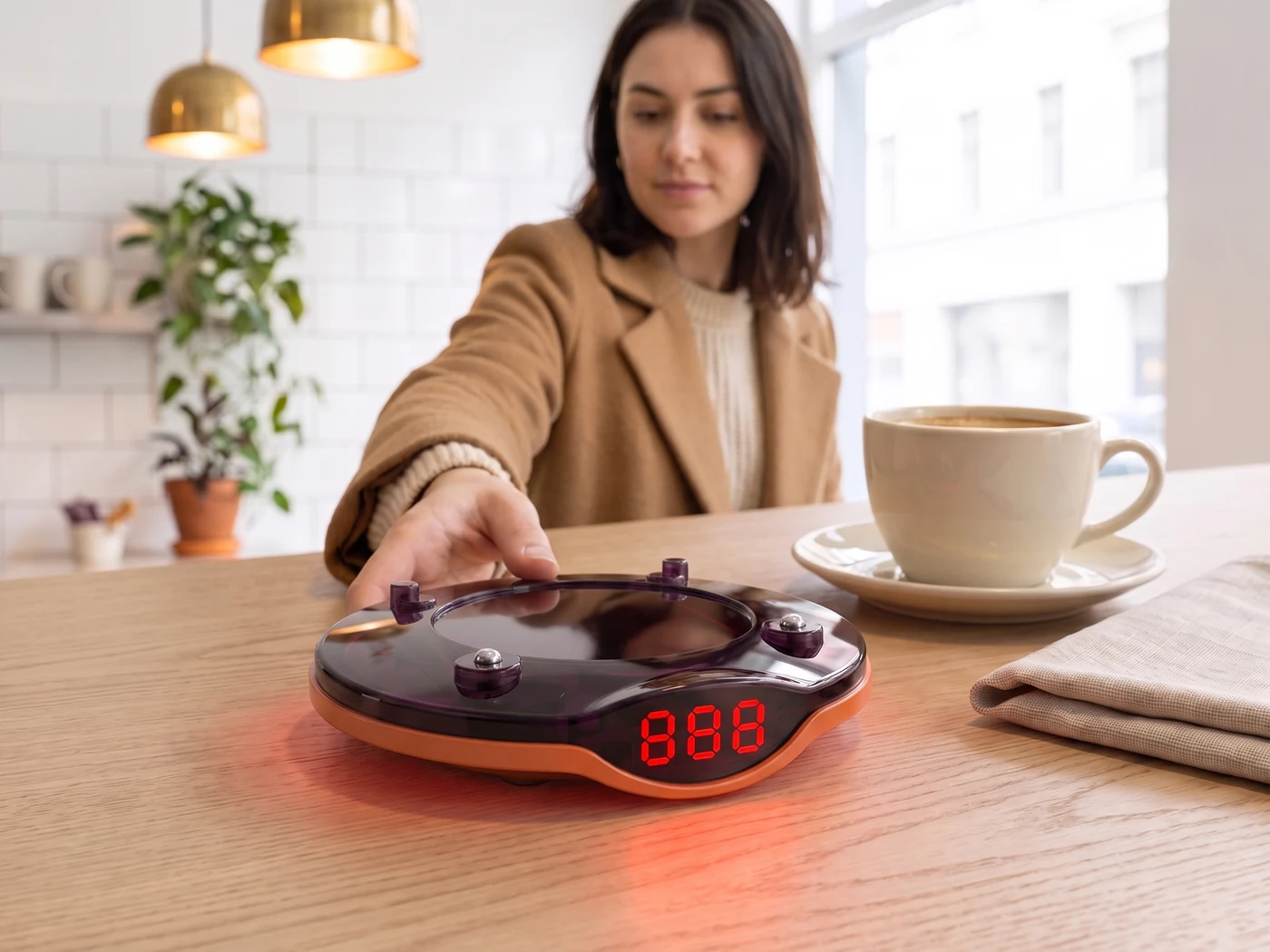 Coffee shop masasında ışıkla uyaran VyCall pagere elini uzatan misafir